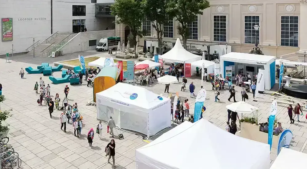 Das Bild zeigt den Danubeday im Museumsquartier. Zahlreiche junge Leute sind bei unterschiedlichen Ständen unterwegs und informieren sich über den Lebensraum Donau.