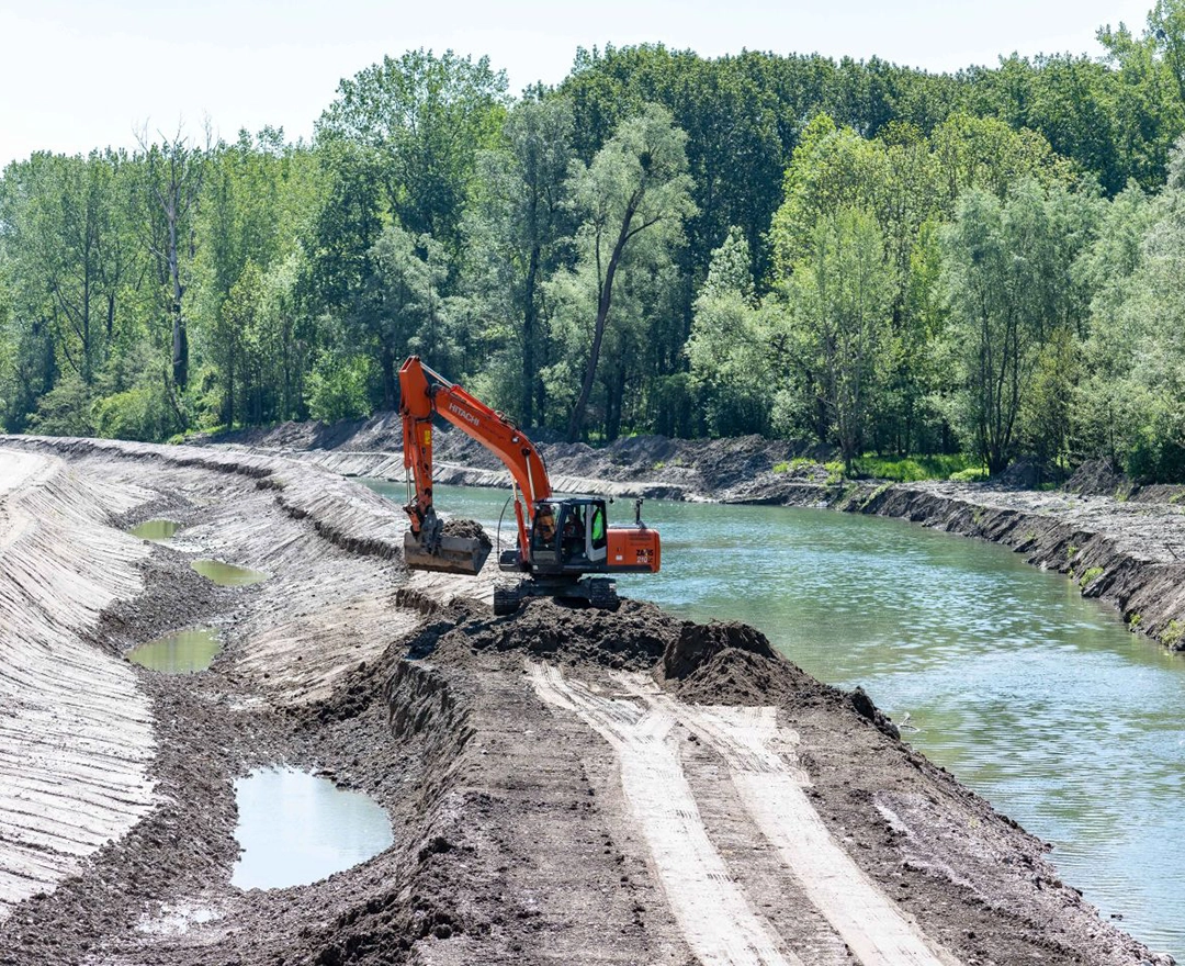 Vorbereitung für die Fischwanderhilfe bei Abwinden-Asten: Ein Bagger bearbeitet bereits das Ufer eines schmalen Flusses.