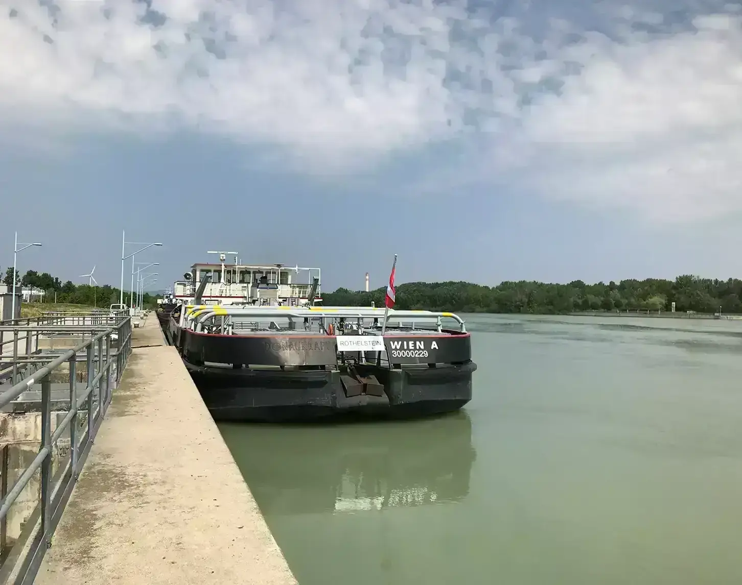 The ship Röthelstein is anchored on the Danube under a bright blue sky.